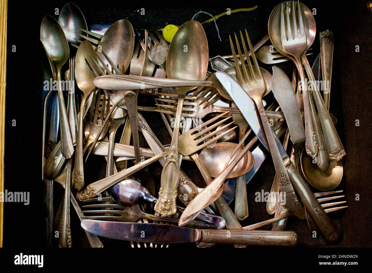 Mucchio di argenteria vecchia, tra cui coltelli, forchette e cucchiai in foto dall'alto al mercato delle pulci di Brooklyn. Foto Stock