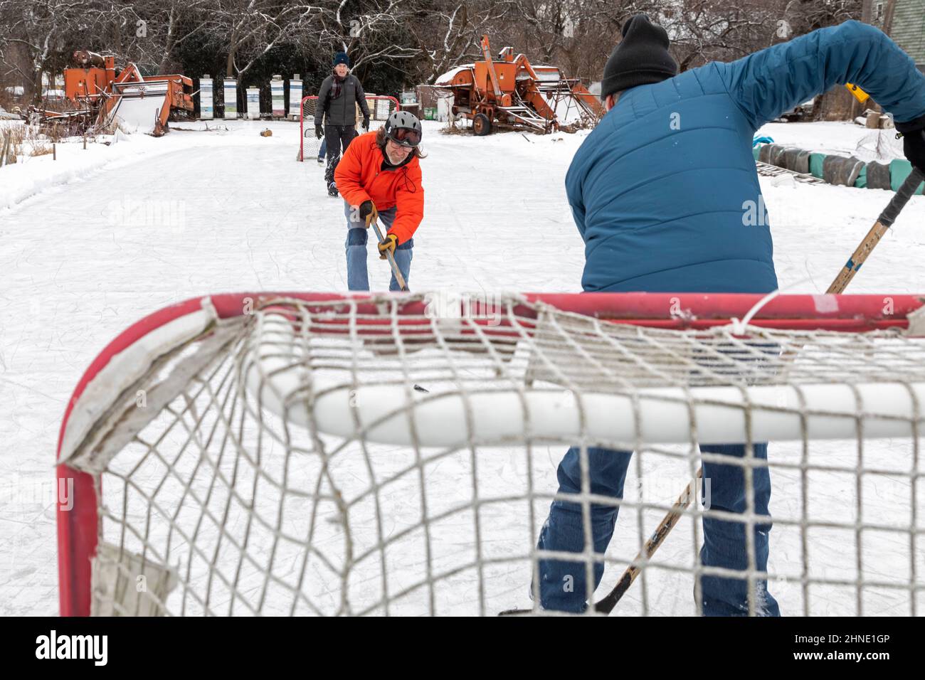 Detroit, Michigan - gli uomini più anziani giocano a hockey su ghiaccio su una pista di pattinaggio sul ghiaccio del cortile posteriore. Foto Stock