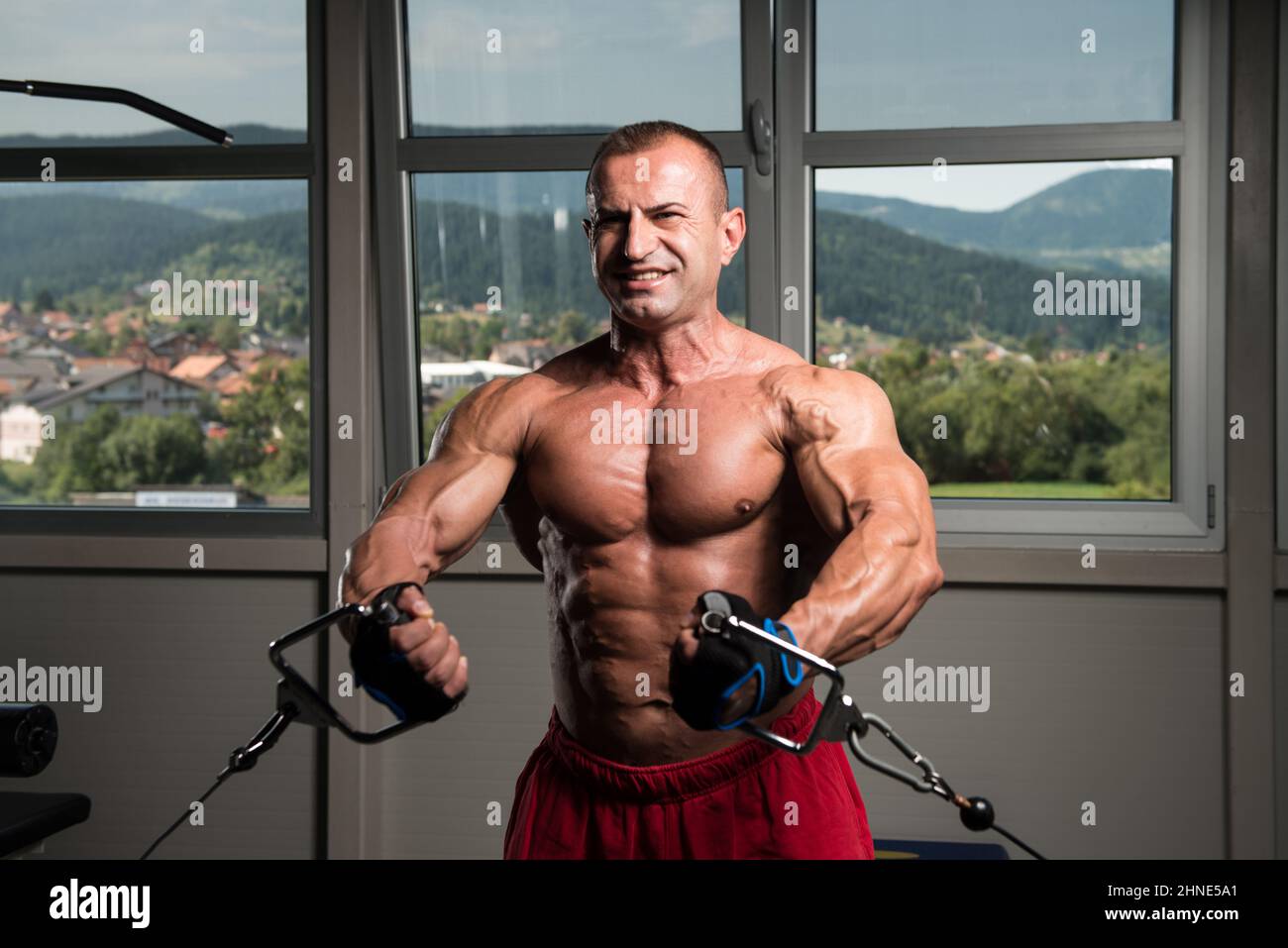 Allestitore è al lavoro sul suo petto con cavo crossover in palestra Foto Stock