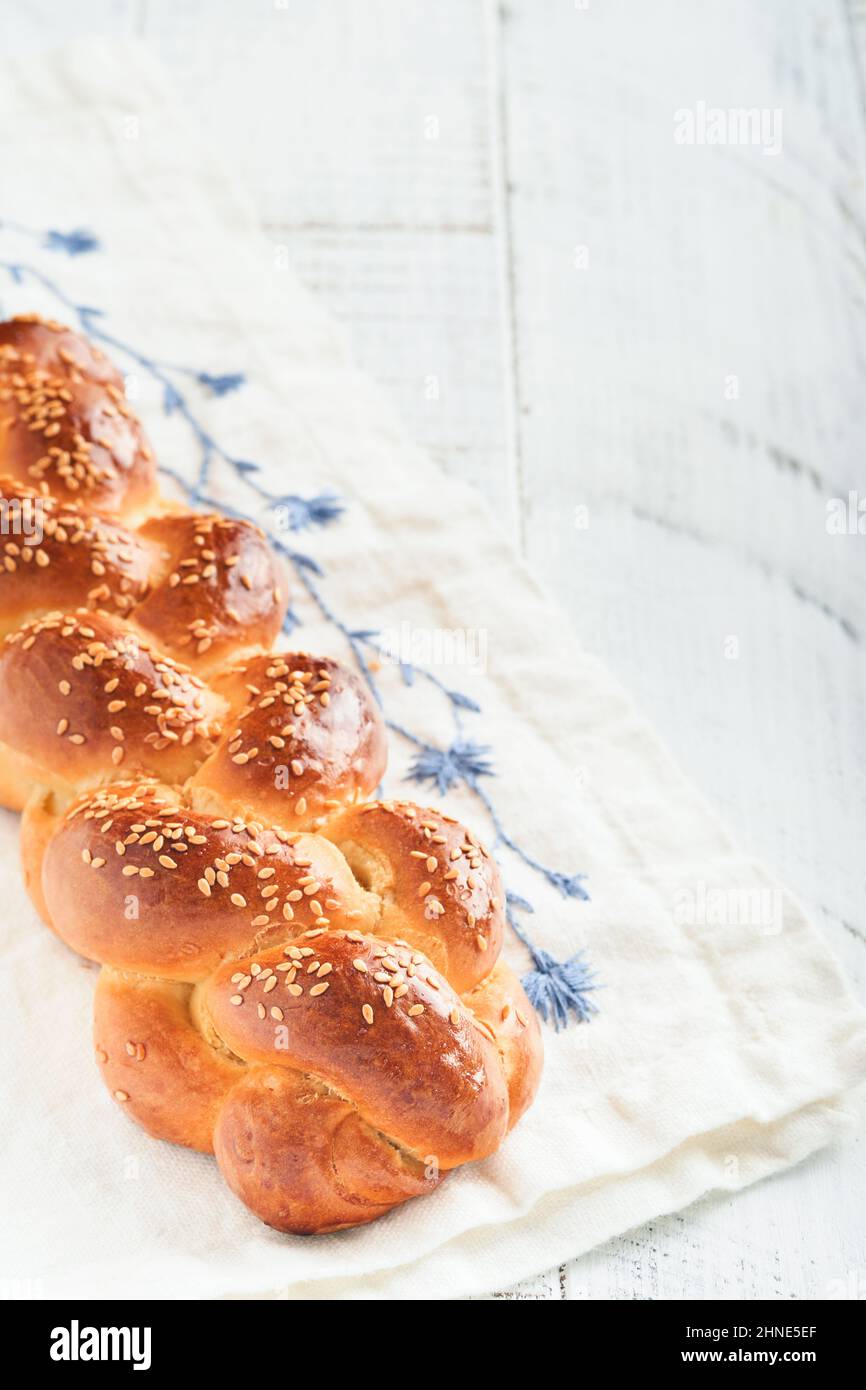 Pane di Challah. Composizione della cerimonia di rapimento del Sabbath. Pane casereccio alla sfida intrecciato appena sfornato per Shabbat e feste su sfondo bianco di legno, Foto Stock