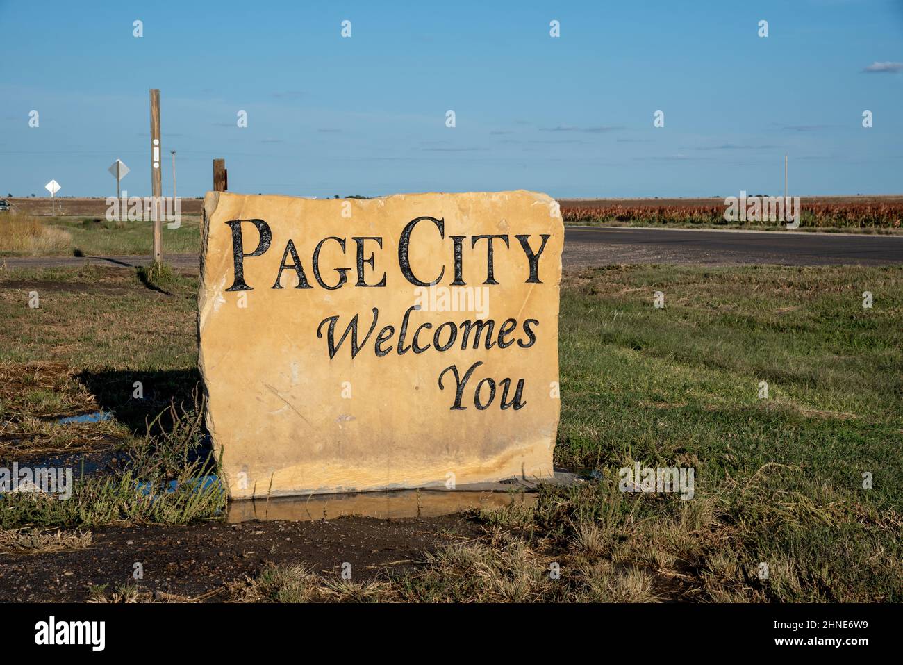 Un cartello di benvenuto scolpito in pietra lungo un'autostrada in Kansas circondato da letture di campagna aperte, Page City vi dà il benvenuto. Foto Stock