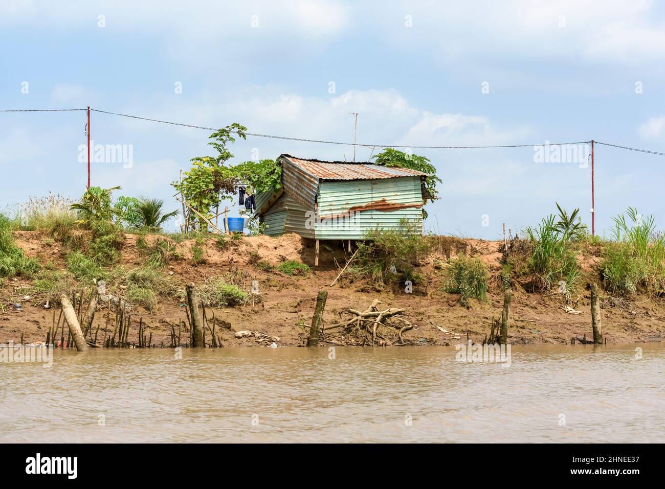 Casa in ferro corrugato rustico sulle rive del fiume Mekong, Delta del Mekong, Provincia di Vinh Long, Vietnam meridionale, Asia sudorientale Foto Stock