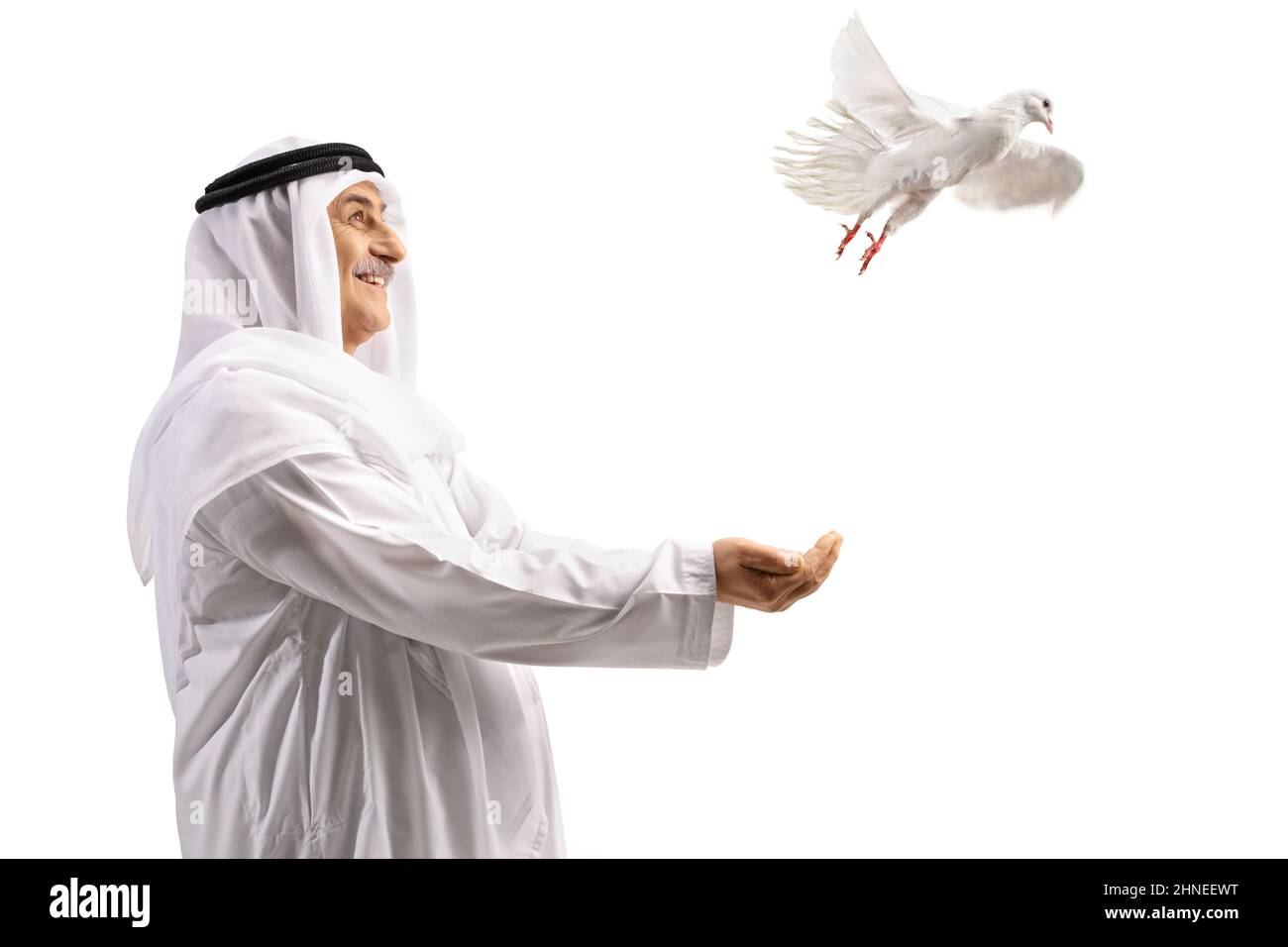 Arabo in abiti etnici sorridendo e lasciando una colomba bianca volare isolato su sfondo bianco Foto Stock