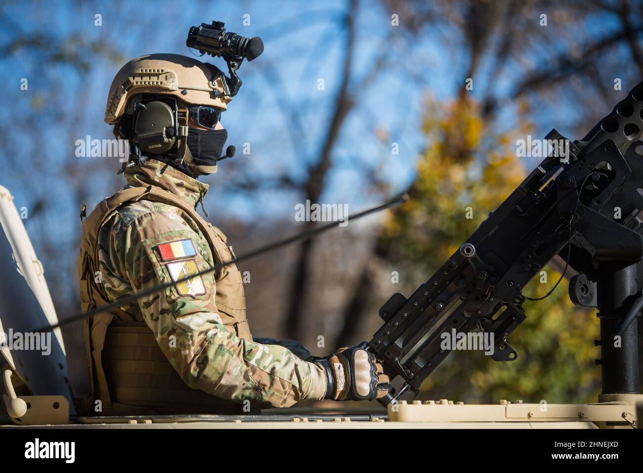 Bucarest, Romania - 1 dicembre 2021: Un soldato tiene una mitragliatrice sul tetto di un corazzatore, durante una parata militare a Buchares Foto Stock