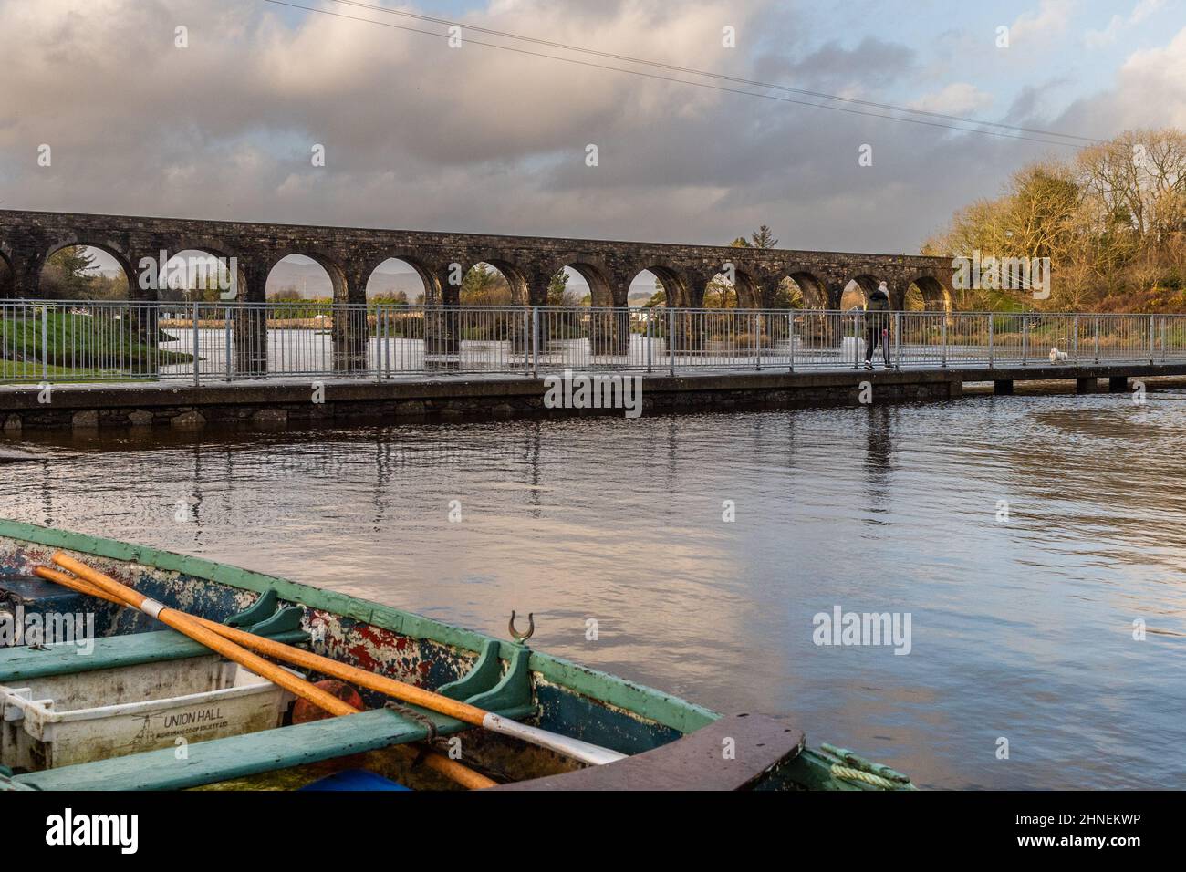 Ballydehob, West Cork, Irlanda. 16th Feb 2022. Storm Dudley ha colpito l'Irlanda oggi con 65KMH venti e raffiche fino a 110KMH. Una donna cammina il suo cane mentre il sole tramonta a Ballydehob dopo un giorno di vento forza di balla e pioggia pesante. Credit: AG News/Alamy Live News Foto Stock
