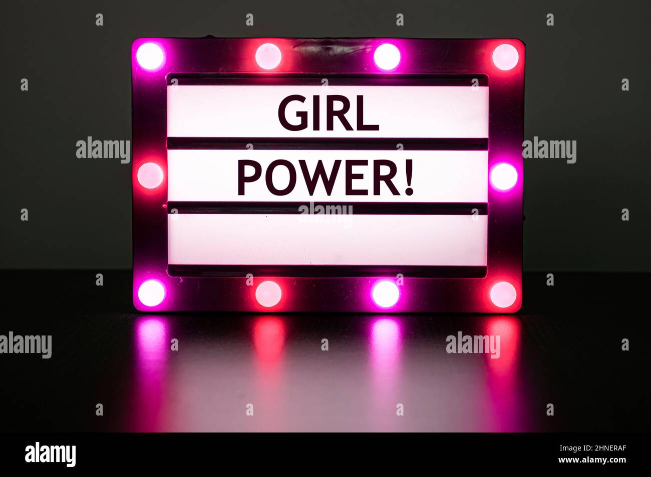 Scatola luminosa con luci rosa in camera oscura con parole - ragazza potere! Foto Stock