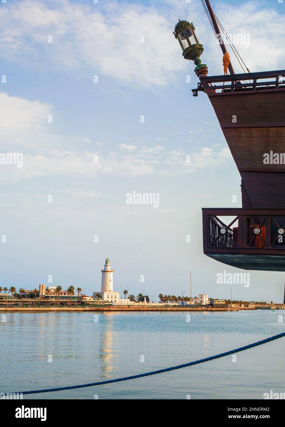 Primo piano di una barca da diporto con il faro del porto di Malaga sullo sfondo. Foto Stock