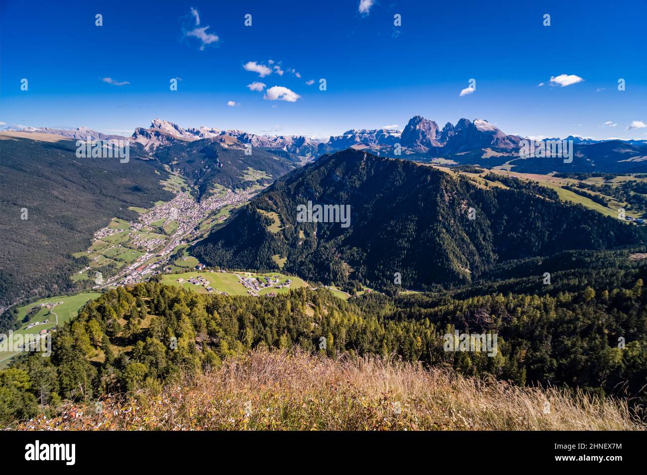 Veduta aerea della Val Gardena e del comune di Ortisei, del gruppo Odle, del gruppo Sella e del Sassolungo in lontananza, vista da Puflatschspitz a Seiser Alm. Foto Stock