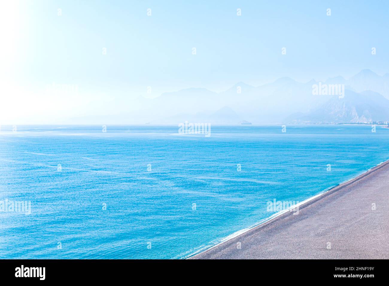 seascape con spiaggia deserta e costa montagnosa lontano in foschia, vista aerea Foto Stock