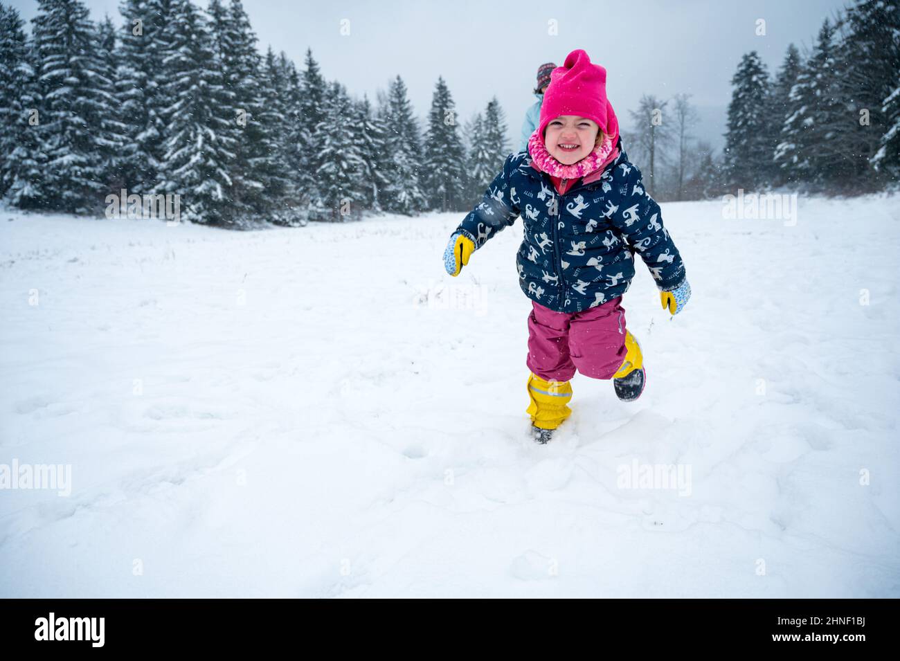 Ragazza felice che corre su neve appena caduta. Foto Stock