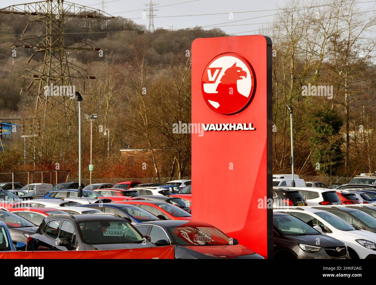 Treforest, Galles - Febbraio 2022: Segno fuori di una concessionaria Vauxhall auto con auto usate in vendita parcheggiata sul piazzale garage Foto Stock