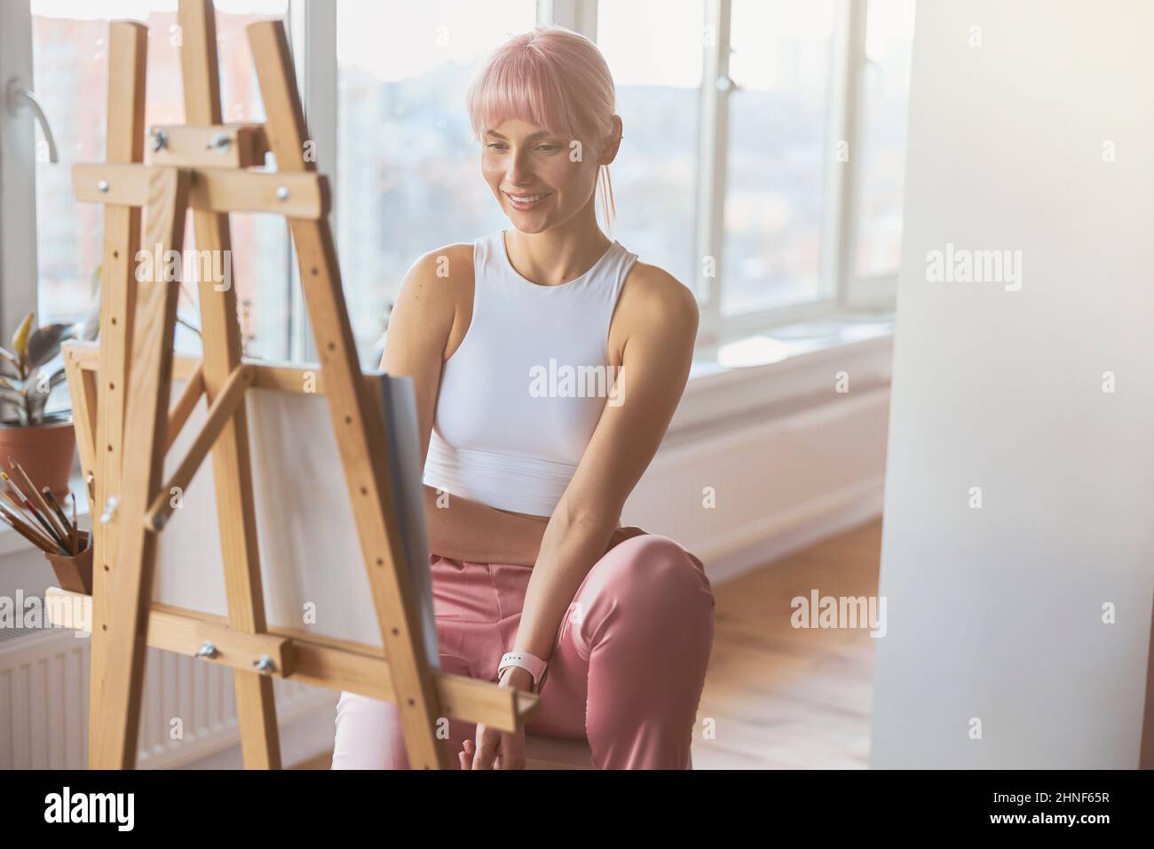Attraente donna artista positivo al lavoro su nuova immagine a casa Foto Stock