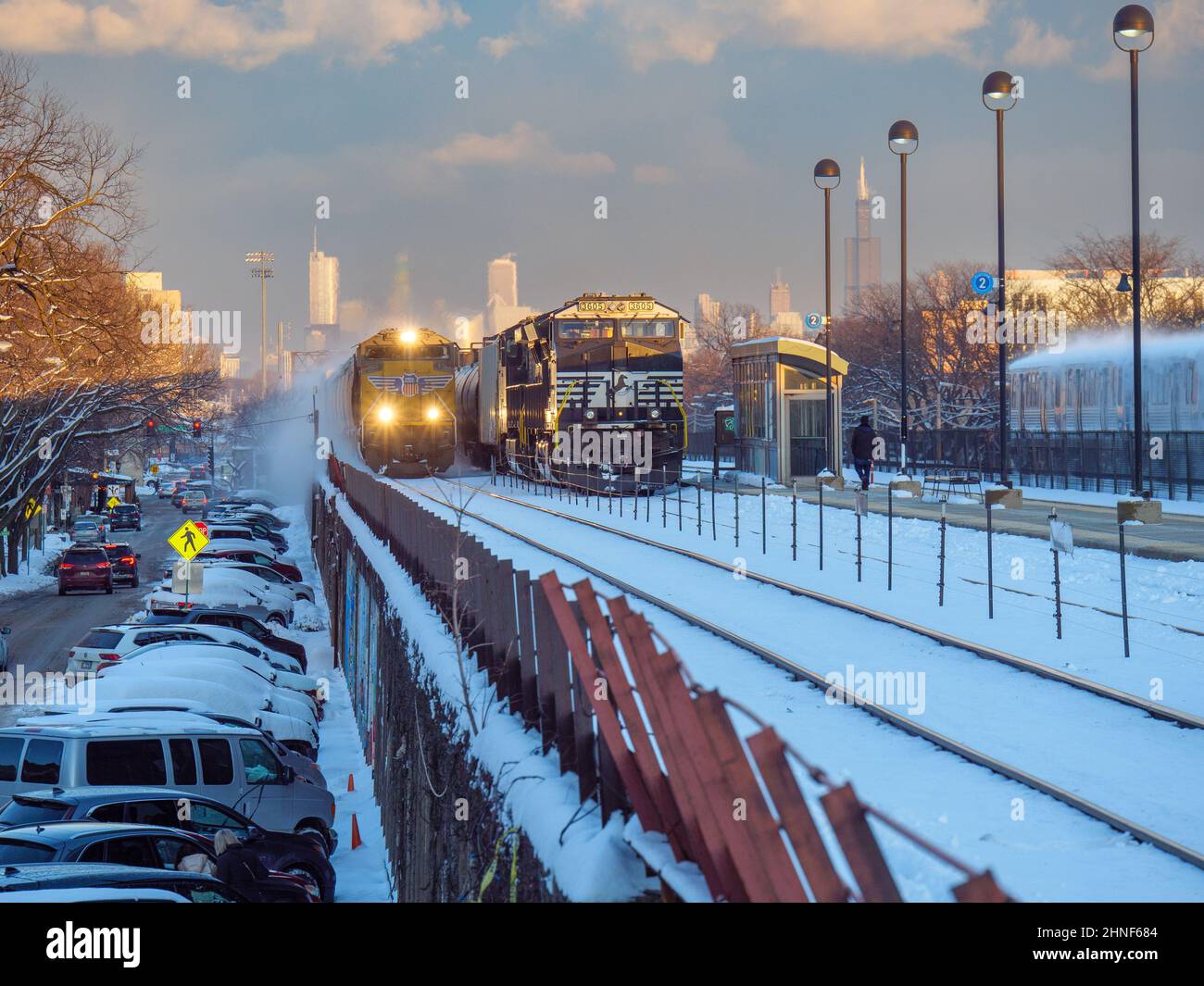 Il treno merci Union Pacific passa per il trasporto merci Norfolk Southern parcheggiato mentre un treno CTA Green Line si dirige verso il centro di Chicago. Foto Stock