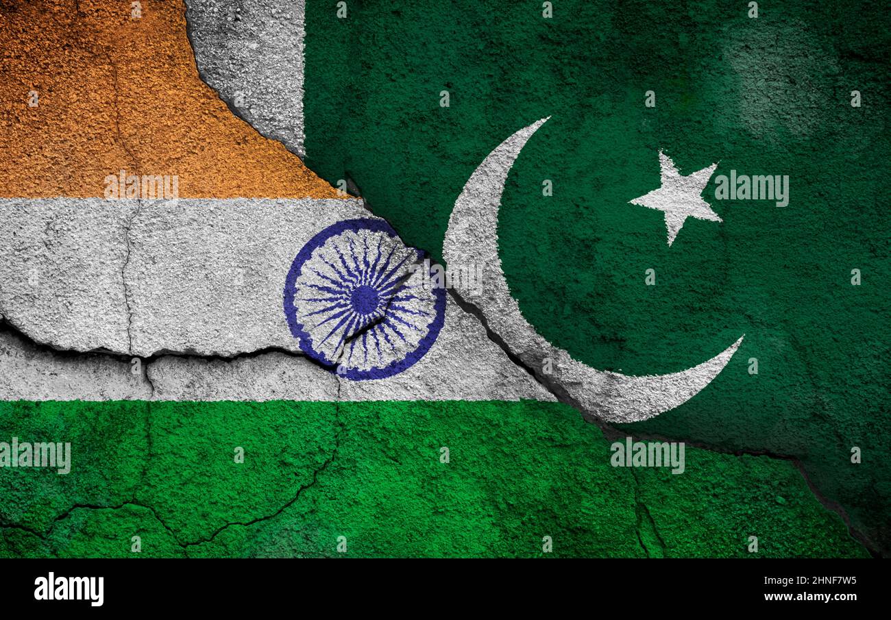 Foto full frame di bandiere intemperie di India e Pakistan dipinte su un muro rotto. Concetto di guerre e conflitti indo-pakistani. Foto Stock