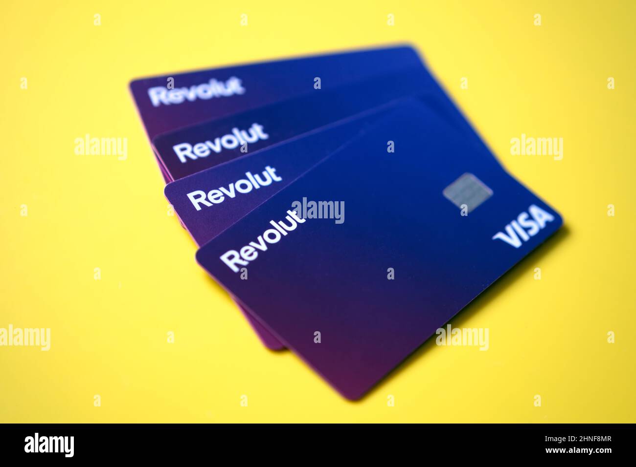 Pila di nuove carte di debito REVOLUT VISA poste su sfondo vibrante. Messa a fuoco selettiva. Stafford, Regno Unito, 16 febbraio 2022. Foto Stock