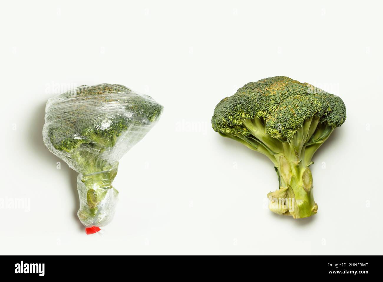 Broccoli confezionati in involucro di plastica e freschi isolati su sfondo bianco Foto Stock
