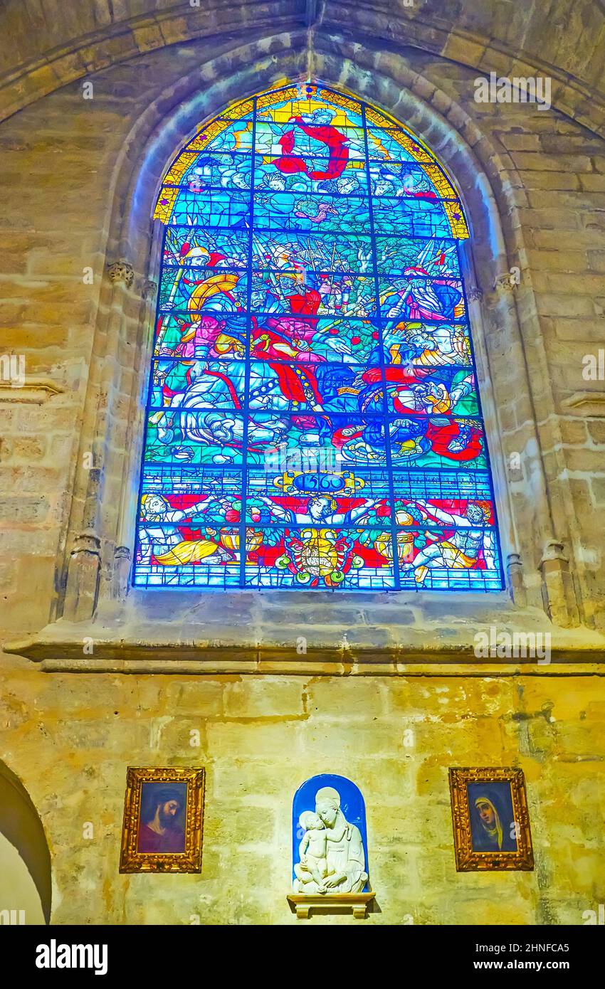 SIVIGLIA, SPAGNA - 29 SETTEMBRE 2019: La colorata vetrata sulle pareti in pietra della cappella di Capilla de Santiago della Cattedrale di Siviglia, il 29 settembre Foto Stock