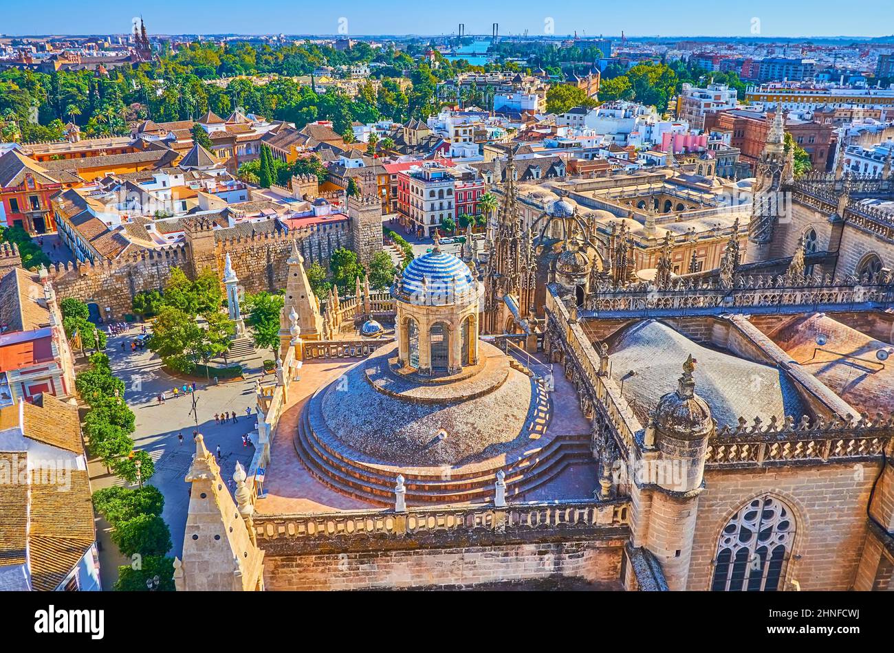 Goditi il paesaggio urbano dalla Giralda con vista sui lussureggianti parchi verdi, sui tetti antichi, sui bastioni dell'Alcazar e sulla cupola della cattedrale di Siviglia, in Spagna Foto Stock