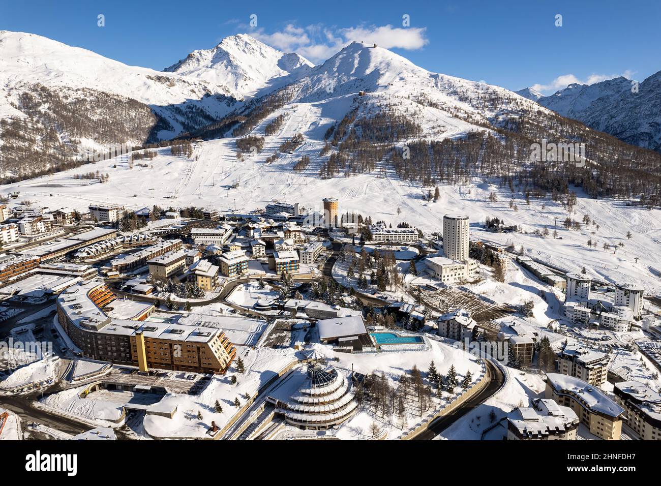 Veduta aerea del villaggio di Sestriere dall'alto, famosa stazione sciistica nelle Alpi occidentali italiane, Piemonte, Italia. Sestriere, Italia - Febbraio, 2022 Foto Stock