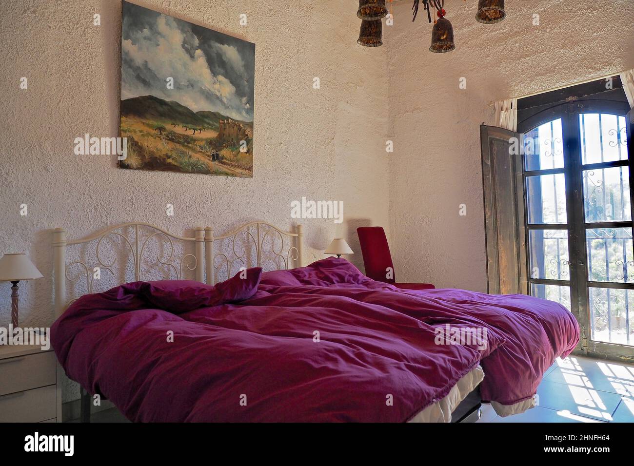Camera da letto con letto matrimoniale imbottito e dipinto ad olio di fronte a persiane aperte, letto, letto matrimoniale, letto matrimoniale, letto singolo, Andalusia, Spagna Foto Stock