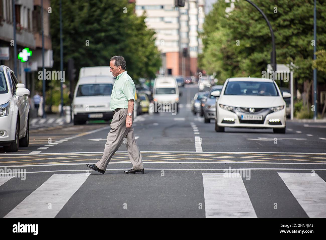 Mobilità nella città di Vitoria, pedoni che attraversano il passaggio pedonale tra le auto. Foto Stock