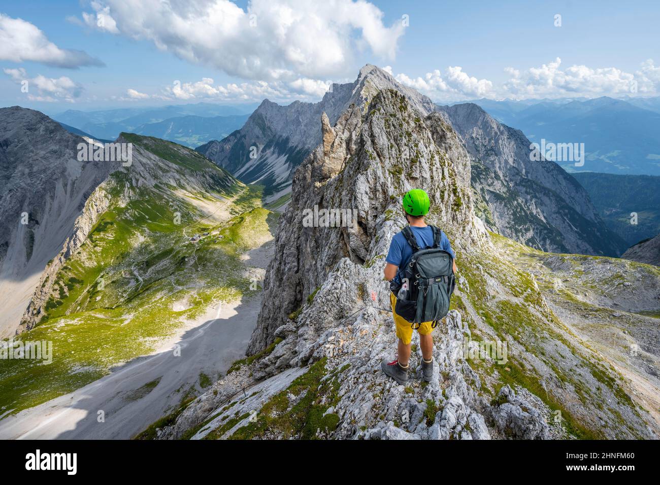 Escursionista al Lamsscharte, cresta rocciosa esposta, sullo sfondo della cima di Hochnissl, sotto Lamsenjochhuette, Vomper Kette, Karwendel montagne Foto Stock