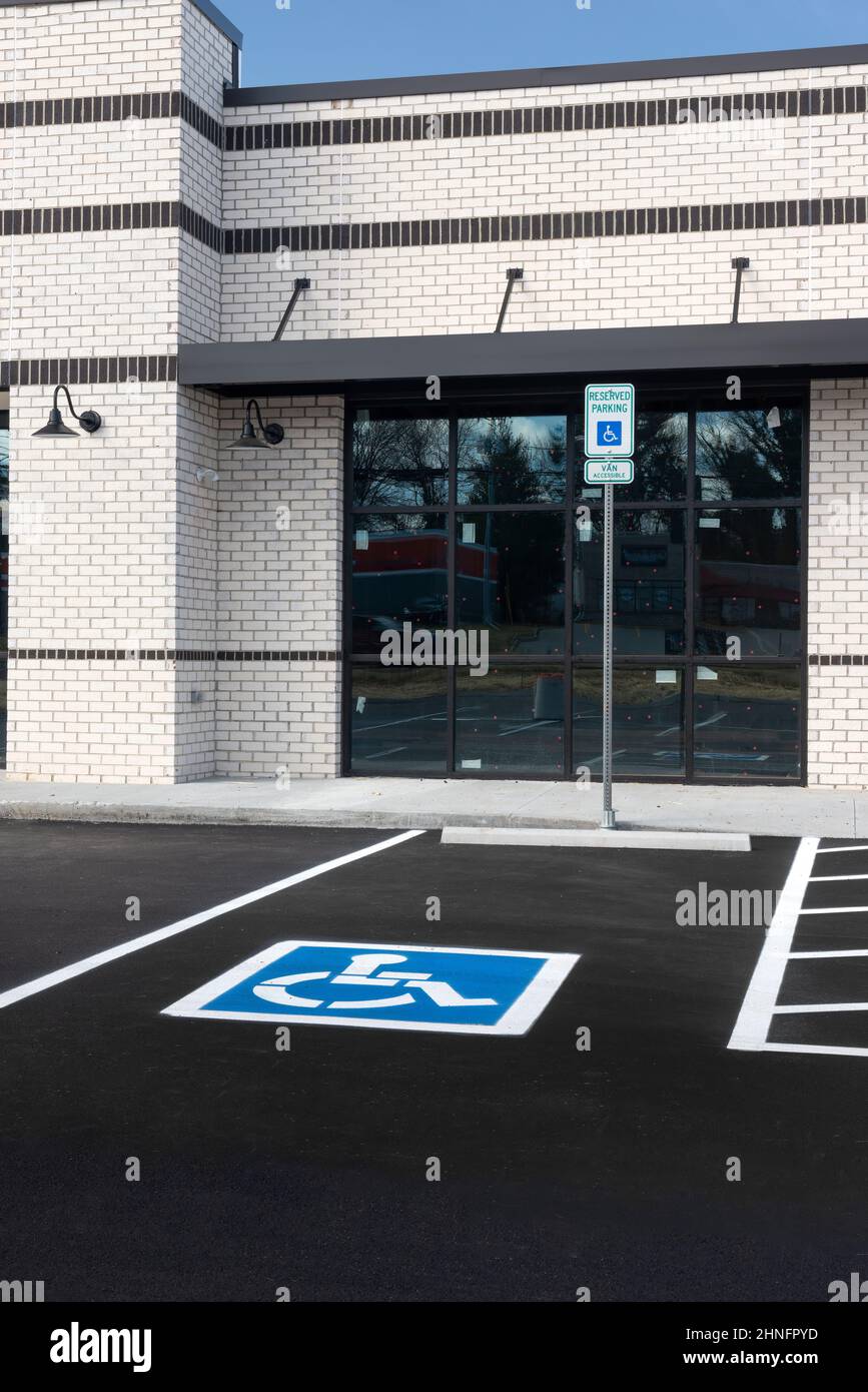 Immagine verticale di un parcheggio per disabili davanti a una nuova costruzione al dettaglio. Foto Stock