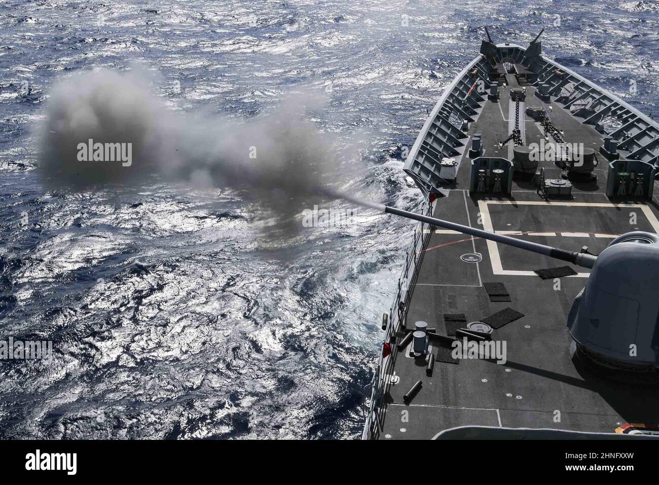 MAR DELLE FILIPPINE (Feb 15, 2022) l'incrociatore missilistico guidato di classe Ticonderoga USS Mobile Bay (CG 53) spara un sistema di armi da 45 5 pollici MK durante un esercizio Naval Surface Fire Support a sostegno dell'esercizio Jungle Warfare 22 (JWX 22) in tutta Okinawa, Giappone. JWX 22 è un esercizio di formazione sul campo su larga scala incentrato sull'utilizzo delle capacità integrate di partner congiunti e alleati per rafforzare la consapevolezza, la manovra e gli incendi di tutti i domini in un ambiente marittimo distribuito. (STATI UNITI Foto Navy di Mass Communication Specialist 3rd Classe Alonzo Martin-Frazier) Foto Stock