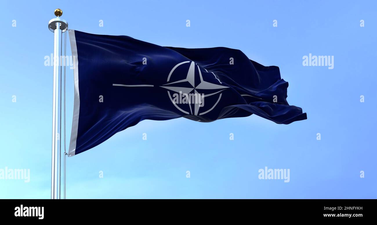 La bandiera della NATO (North Atlantic Treaty Organization) sventola nel vento in una giornata limpida. La NATO è un'alleanza militare internazionale che costituisce un sistema Foto Stock