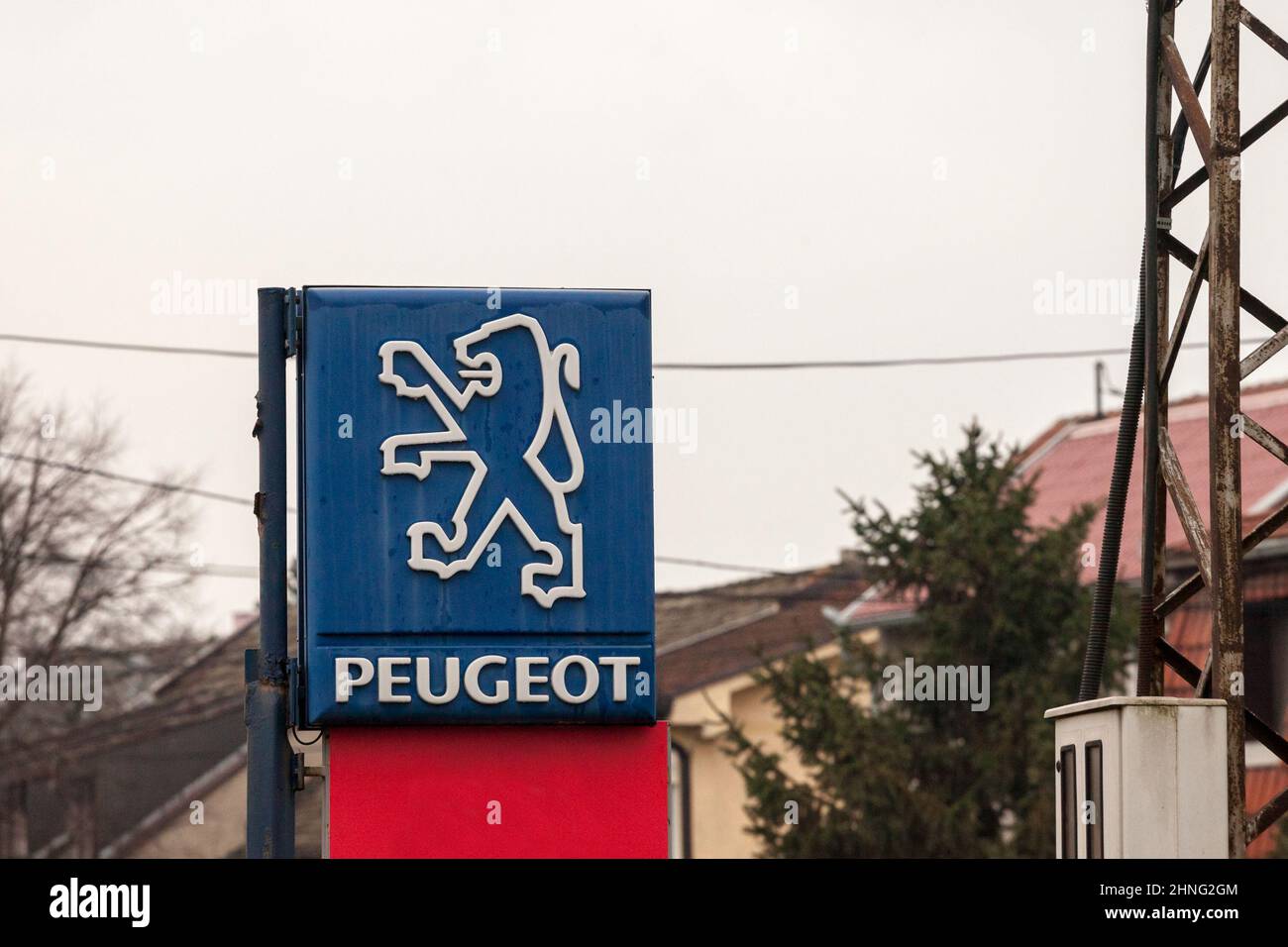 Immagine di un vecchio segno con l'ex logo Peugeot, accanto ad una concessionaria di auto del marchio nella Serbia orientale. Peugeot è una fabbrica automobilistica francese Foto Stock