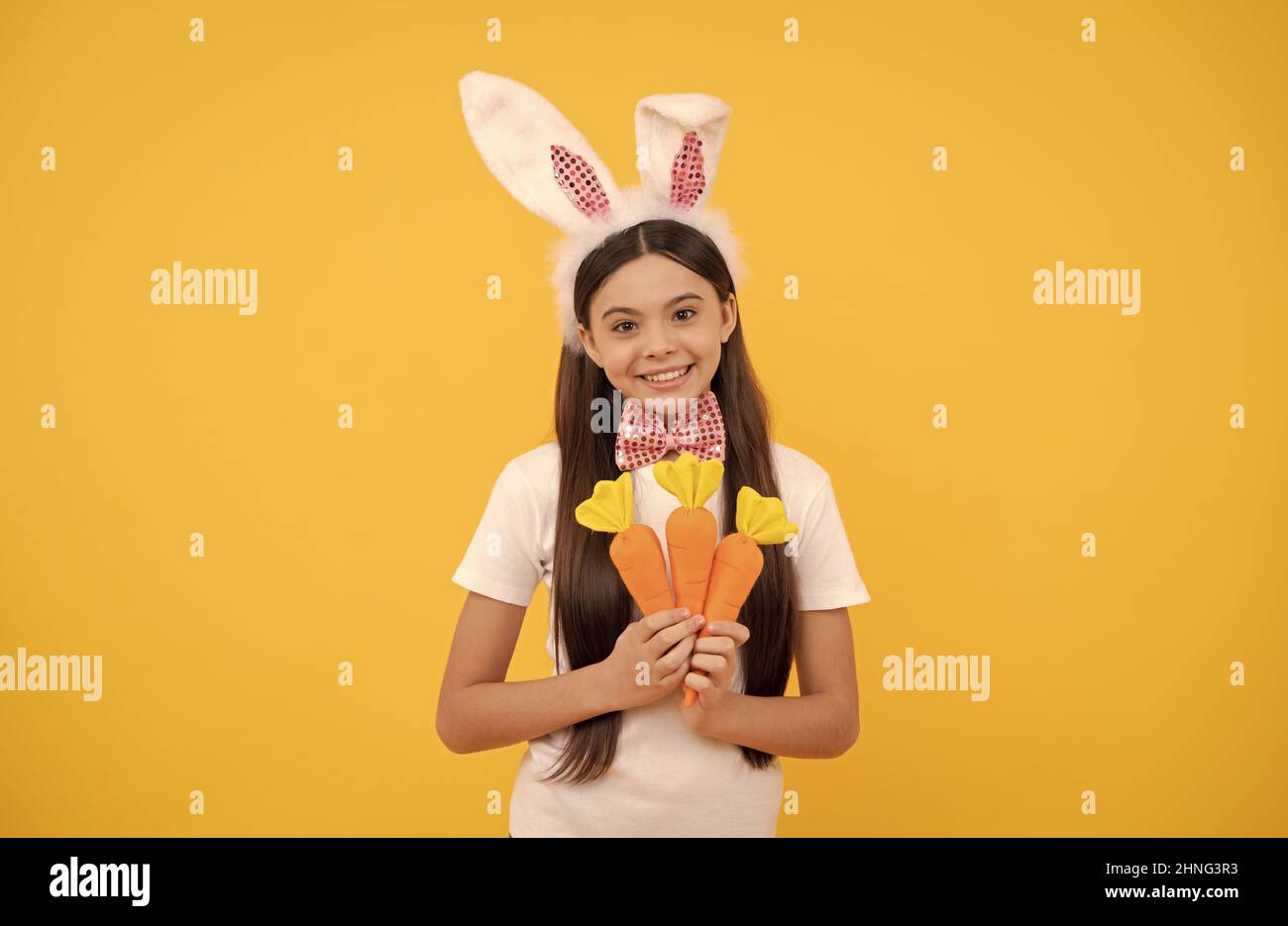 semplicemente perfetto. adorabile ragazzo che guarda divertente con carota. pasqua primavera vacanza. ragazza felice teen Foto Stock