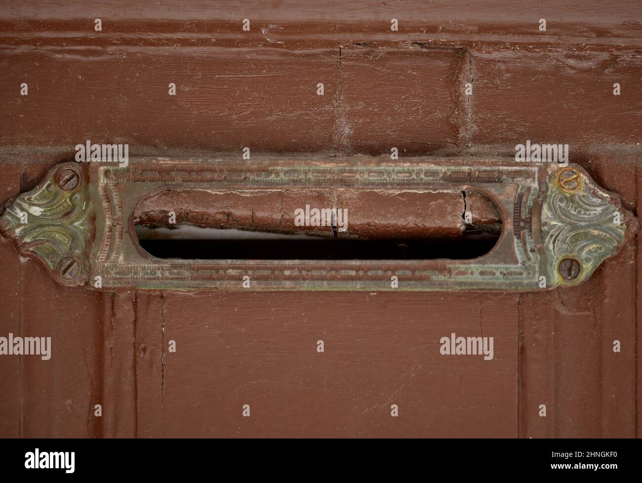 Porta in legno marrone rossastro sbiadito con un'antica scanalatura in ottone a Nafplio, Grecia. Foto Stock