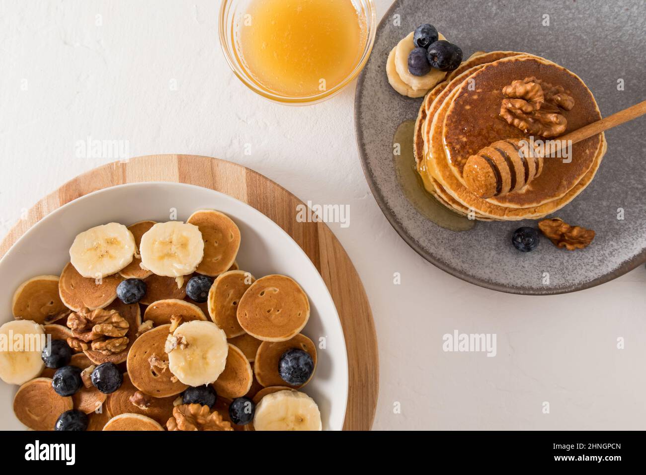 pancake minuscoli - colazione sana e carina - un nuovo concetto di tendenza alimentare. un ottimo spuntino con frutta, frutti di bosco, miele, latte. vista dall'alto Foto Stock