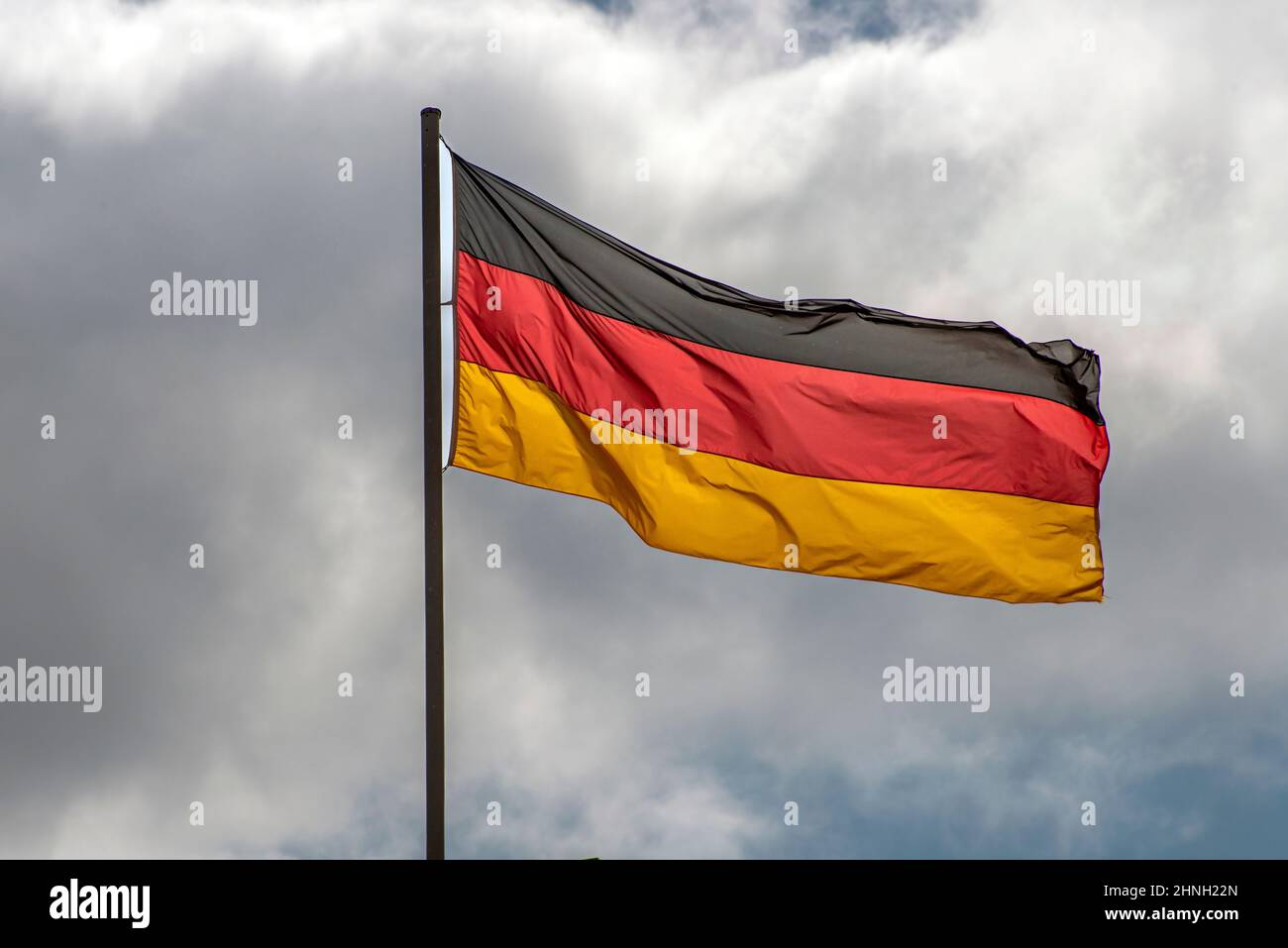 Bandiere tedesche ondeggiavano nel vento nel famoso edificio del Reichstag, sede del Parlamento tedesco (Deutscher Bundestag), in una giornata di sole con la zica blu Foto Stock
