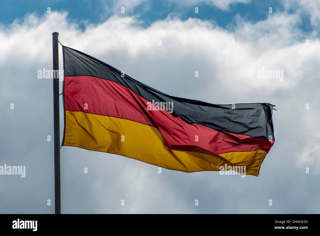Bandiere tedesche ondeggiavano nel vento nel famoso edificio del Reichstag, sede del Parlamento tedesco (Deutscher Bundestag), in una giornata di sole con la zica blu Foto Stock