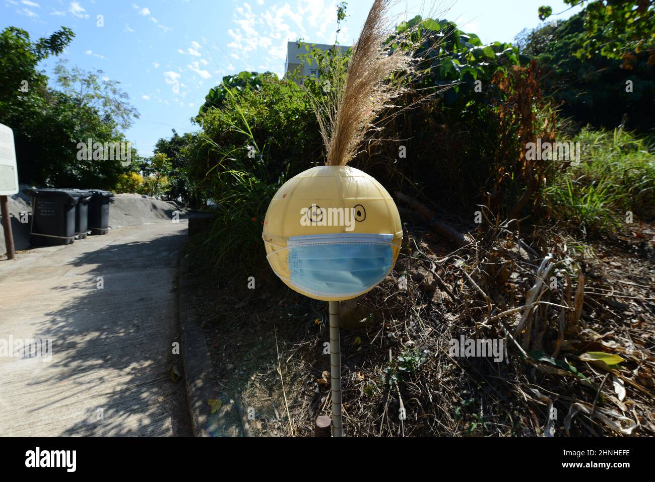 'Si prega di mettere su maschera' prima di entrare nel cartello di scarecrow villaggio in un villaggio sull'isola di Lamma a Hong Kong. Foto Stock