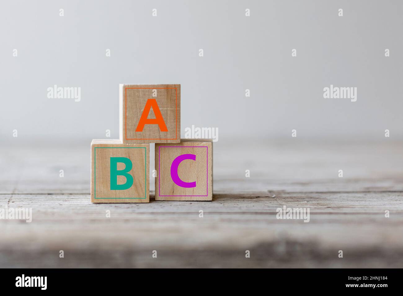 Concetto di analfabetismo. ABC lettere alfabeto su blocchi di cubo di legno su un tavolo di legno Foto Stock