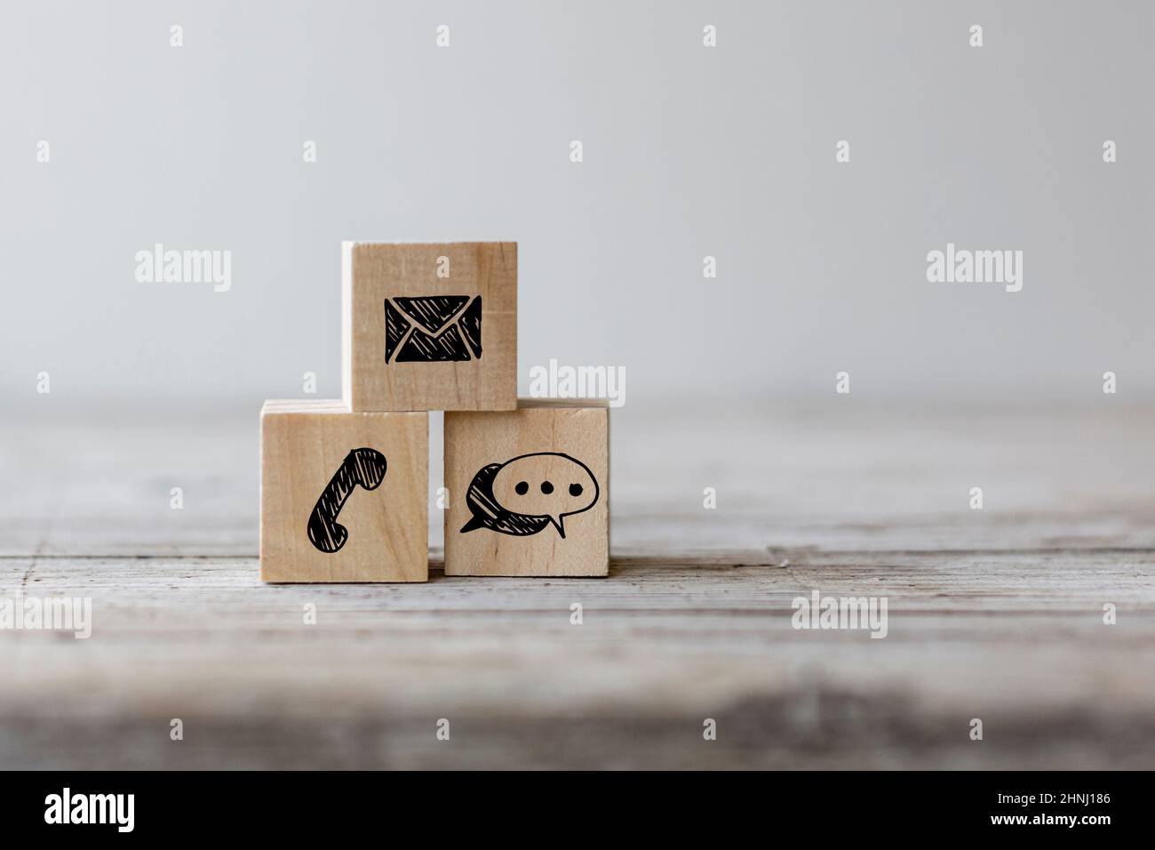 Concetto di contatto del sito Web. Blocco di legno cubo simbolo telefono, posta, indirizzo su un tavolo di legno Foto Stock