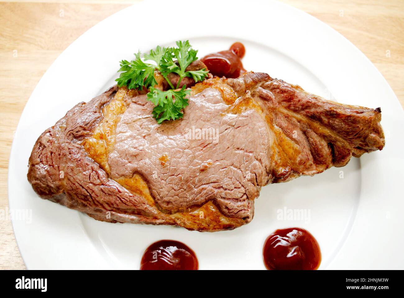 Mediamente rara bistecca di manzo alla griglia su un piatto bianco Foto Stock