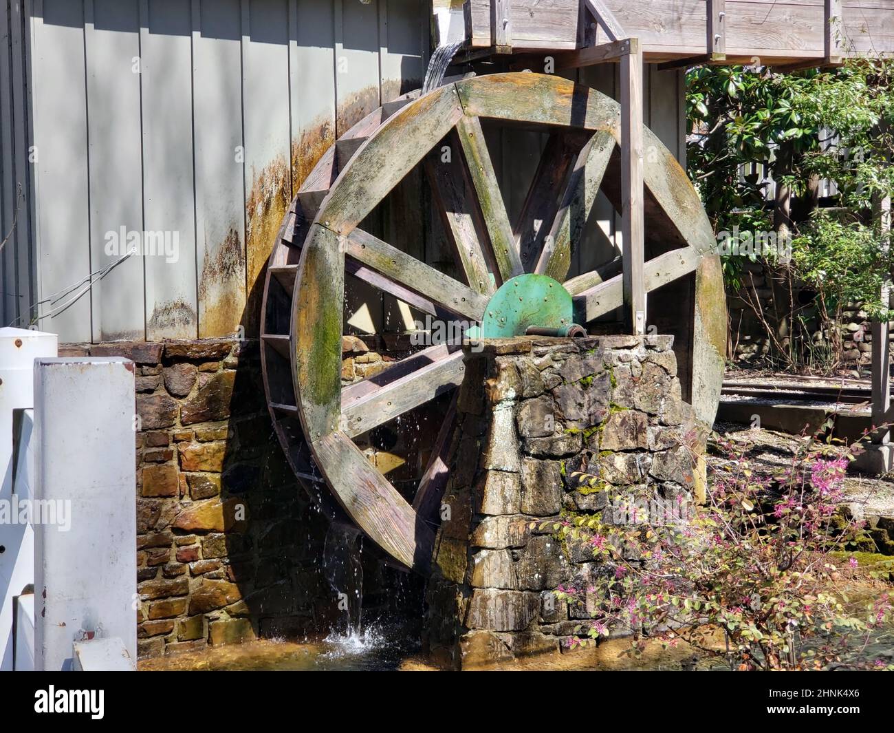 Ruota d'acqua in legno pietra base spruzzi d'acqua Foto Stock