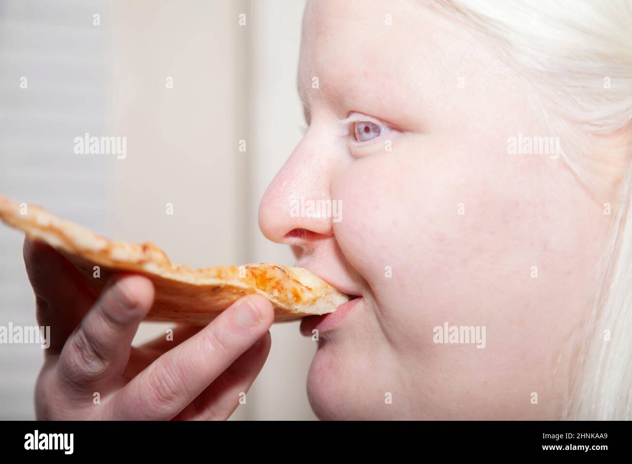 Albino Donna mangiare Pizza indietro Foto Stock