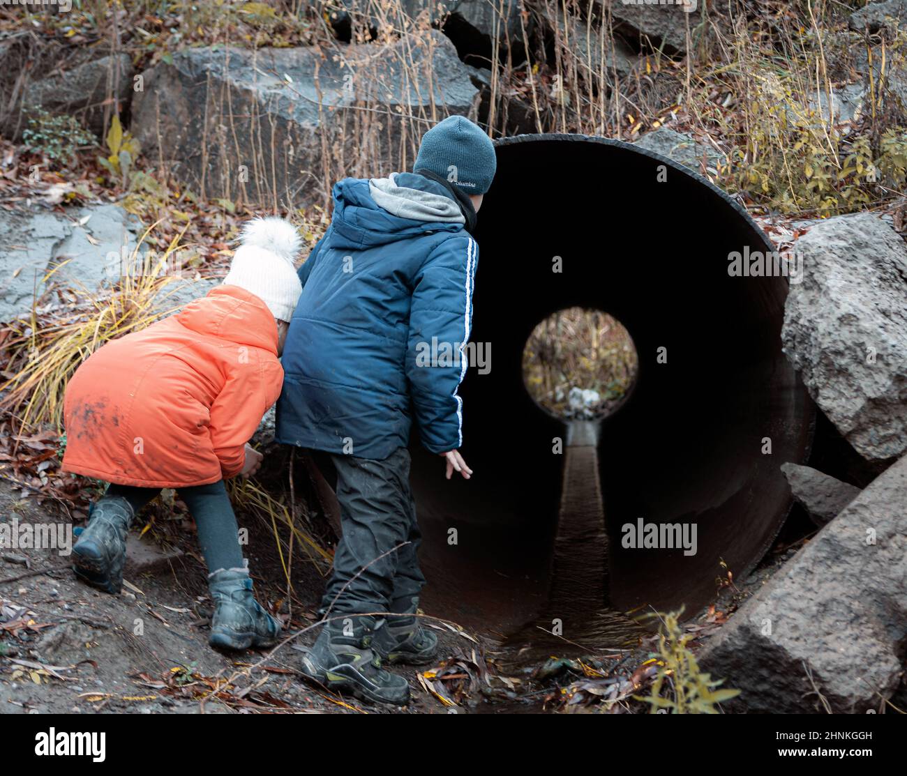 due bambini camminano e guardano la tubatura all'aperto Foto Stock