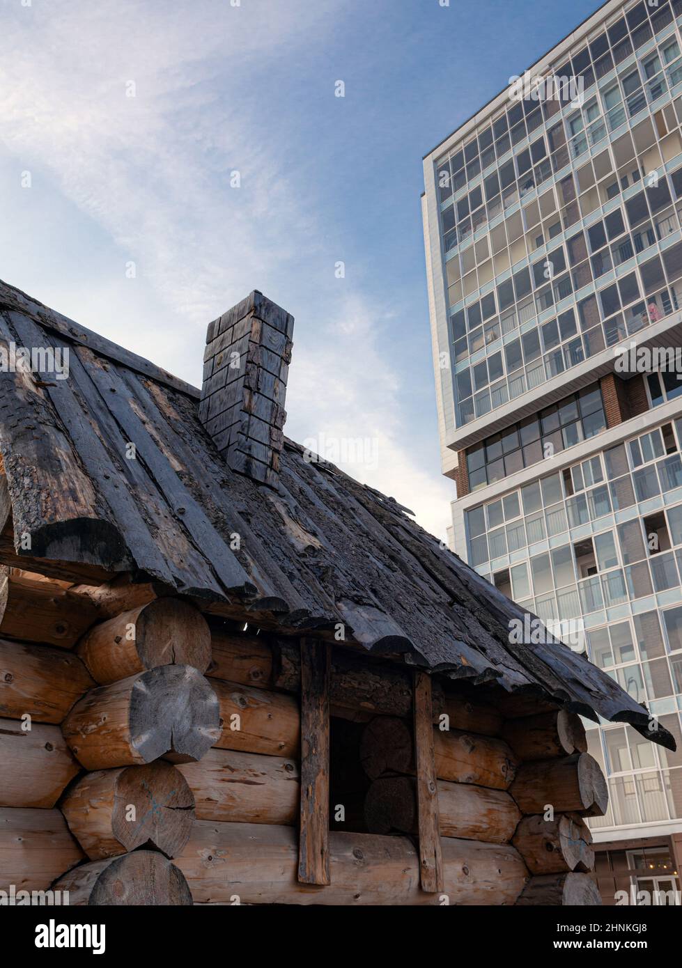 capanna di legno sullo sfondo di un edificio a più piani Foto Stock