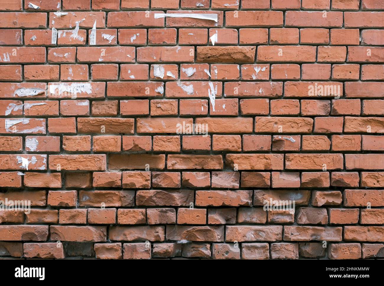 Un vecchio muro di mattoni broccati sfondo colorato Foto Stock