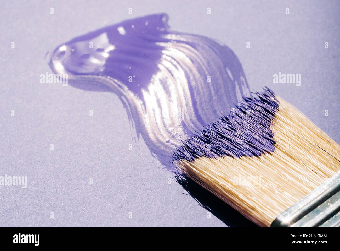 Pennello con vernice acrilica viola o viola su sfondo viola Foto Stock