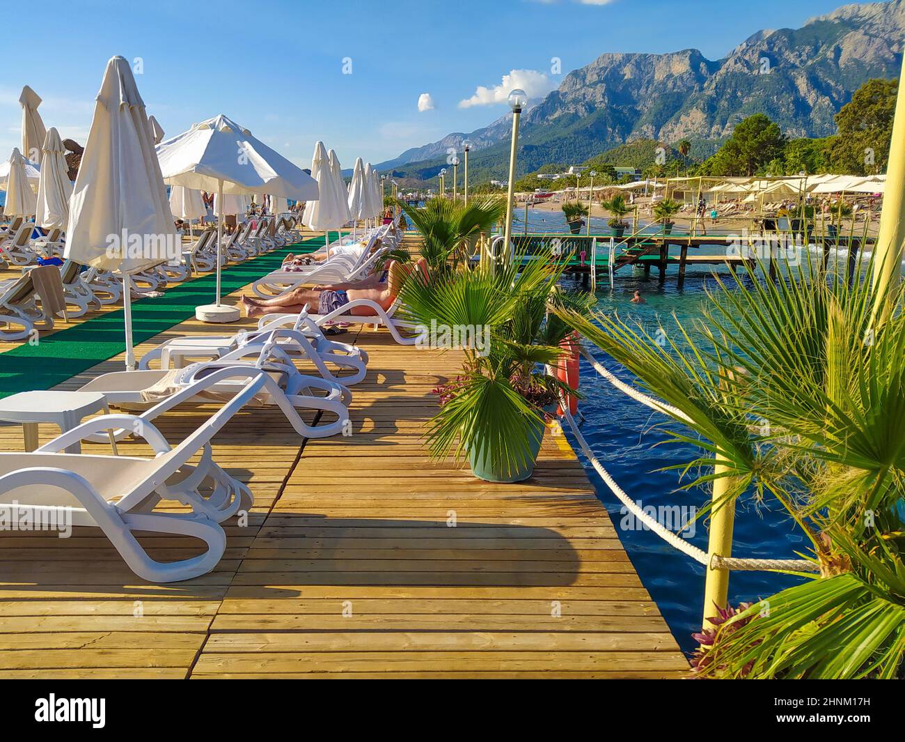 Costa del mare con i moli e le montagne del resort sullo sfondo a Kemer, Turchia Foto Stock