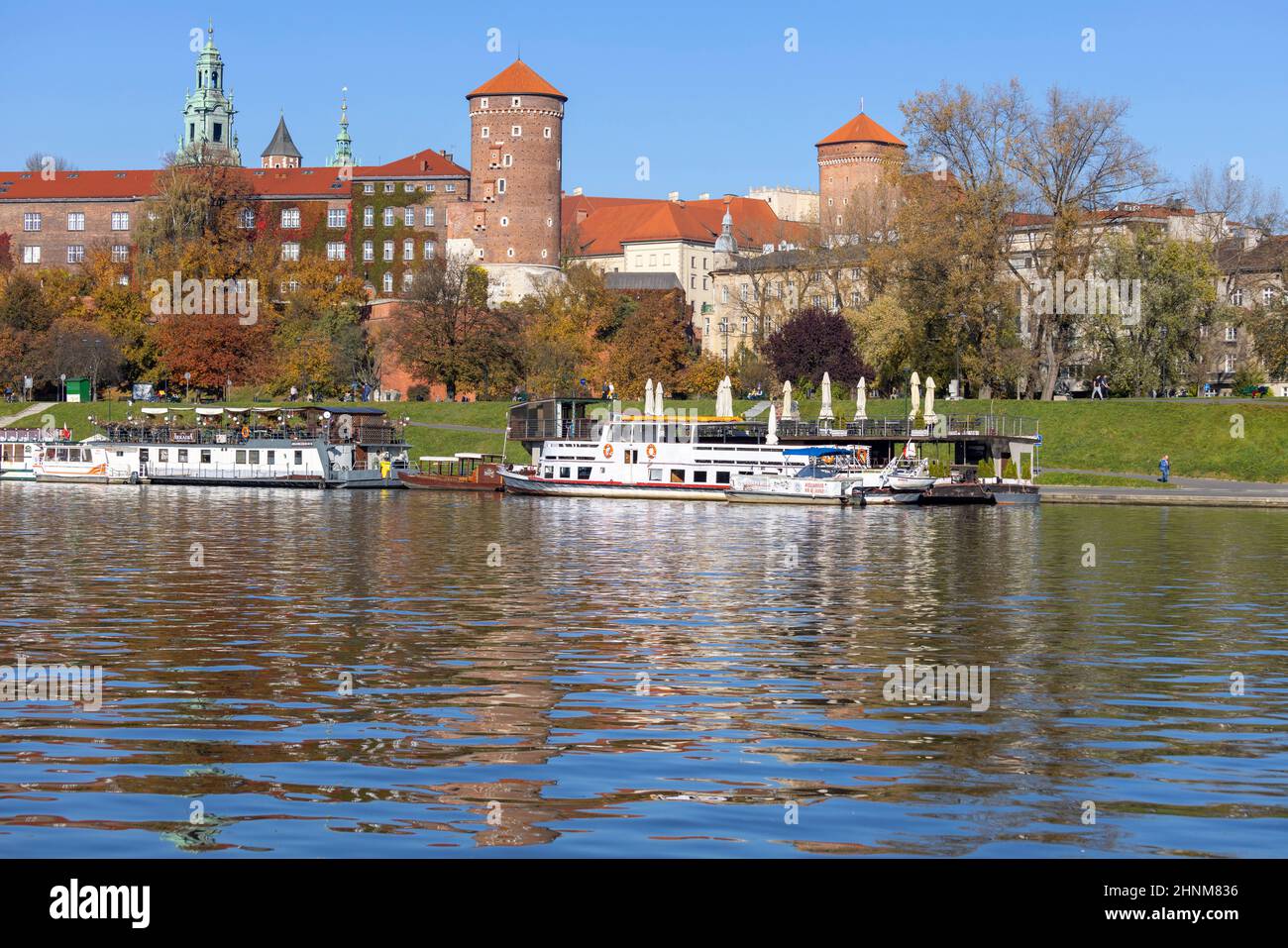 Castello reale di Wawel, vista dal lato del fiume Wisla in autunno, chiatte e ristoranti, Cracovia, Polonia Foto Stock