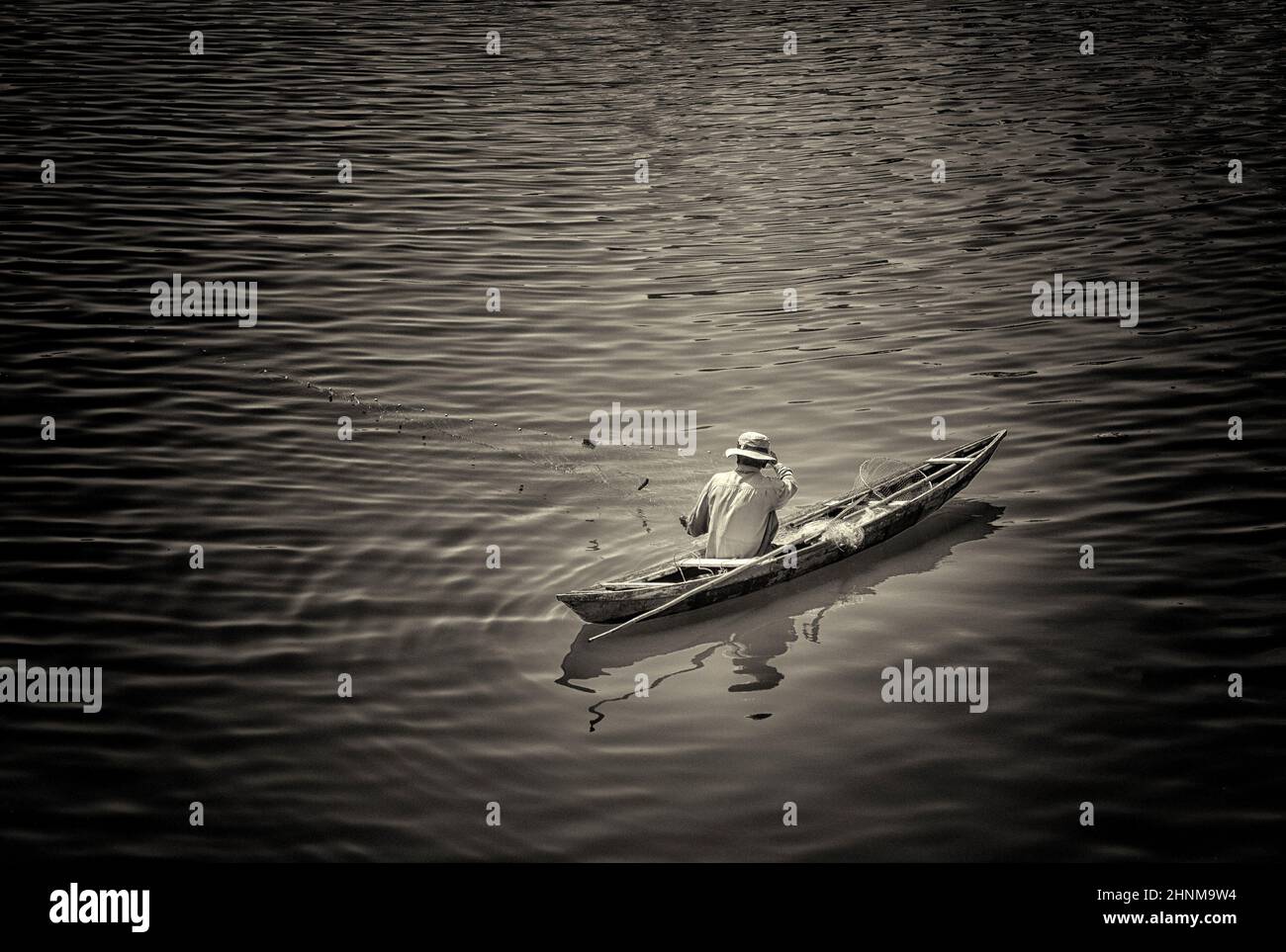 Un pescatore nelle navi pescatore cattura il pesce con la rete Foto Stock