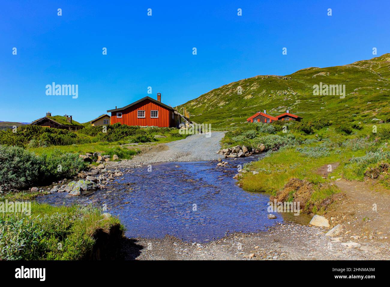 Capanne rosse norvegesi, fiume del lago Vavatn a Hemsedal, Norvegia. Foto Stock