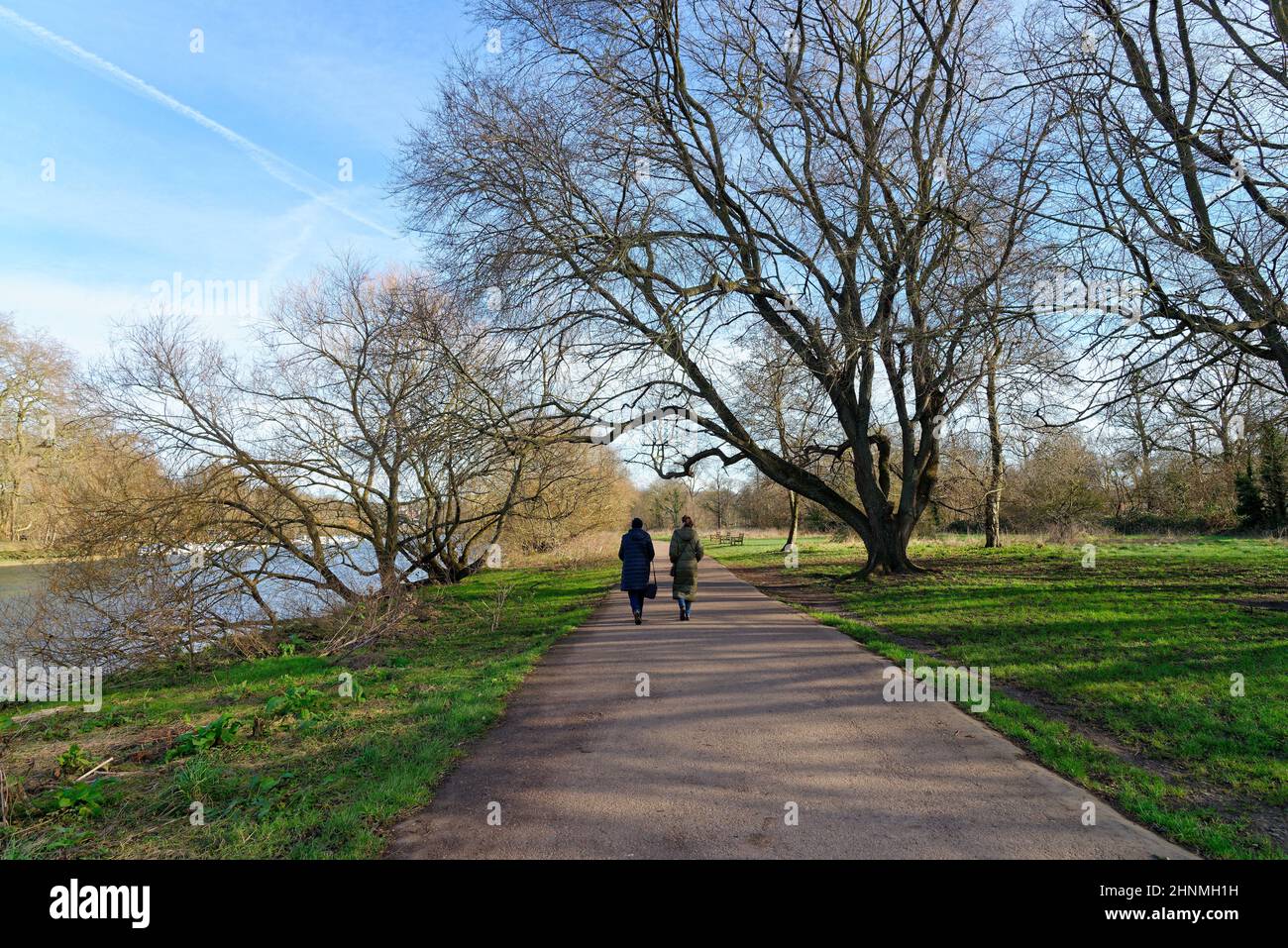 Vista posteriore di due donne godendo di una passeggiata di un giorno di inverni sul percorso dal Tamigi a Ham, Richmond West London Inghilterra UK Foto Stock
